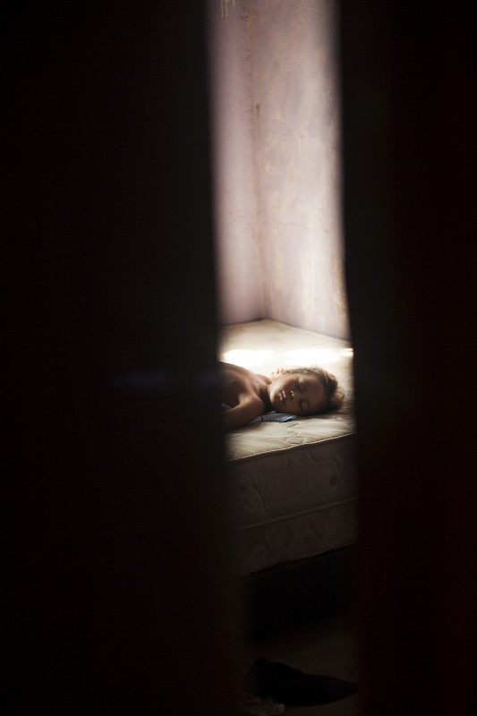 Esecilis, 5, takes a nap at her grandmother Gavelys' house, who often takes care of her grandchildren during the day. It is always hovering around 95-100 degrees in Membrillar. Because of their prior separation, Gavelys' family now clings together.