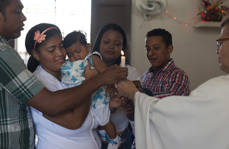 At Omayda's granddaughter's baptism, a few months before her son (left) was shot by cops on accident at a birthday party. Omayda's family, like many in El Refugio, are very religious. Despite the oftentimes desperate situation of money and work, &quot;If God should want it&quot; is a common, if not comforting, refrain.