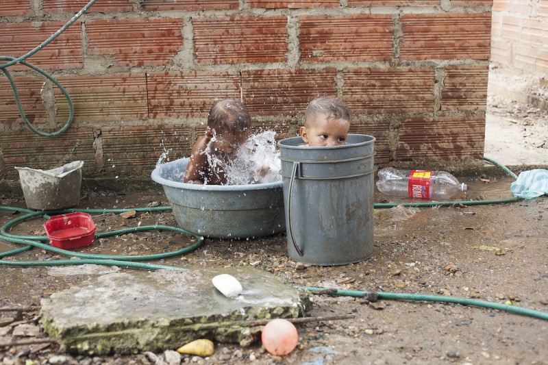Neymar and Sebastian taking a bath in Barrio Membrillar, a community of cinder block and wood houses built by people who have been internally displaced. The boys' grandmother, Gavelys, was displaced from Atanquez, Valledupar, in 2006.