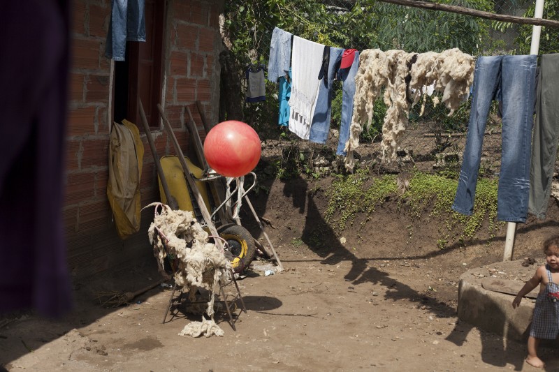 Wool dries on the clothesline in Gavelys' back yard. She weaves the traditional Indigenous bags and sells them in El Centro. A part of her story was told in the women's play at FUNSAREP; the episode whrein the FARC returned to her farm and slaughtered the livestock as a threat.